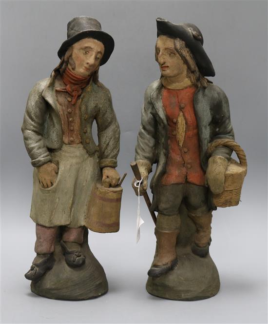 A pair of 19th century French painted terracotta figures of peasants, height 48cm